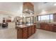 Open-concept kitchen with stainless appliances, island, and breakfast bar overlooks the dining and living areas at 9686 W Keyser Dr, Peoria, AZ 85383