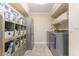 Practical laundry room with modern appliances, storage cabinets, and ample shelving at 9686 W Keyser Dr, Peoria, AZ 85383