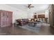 Cozy living room with comfortable leather sofa, area rug, and a ceiling fan at 9686 W Keyser Dr, Peoria, AZ 85383