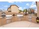 An outdoor kitchen with multiple built-in stainless steel appliances, offering great functionality for outdoor entertaining at 9686 W Keyser Dr, Peoria, AZ 85383