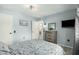 Well-lit bedroom with light blue walls, dresser, and mounted TV at 9918 W Willow Creek Cir, Sun City, AZ 85373