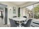 Bright dining area features a round table with modern gray chairs, a decorative wall hanging, and natural light from the window at 9918 W Willow Creek Cir, Sun City, AZ 85373