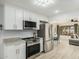 Modern kitchen with stainless steel appliances flows seamlessly into the dining and living spaces with an open concept design at 9918 W Willow Creek Cir, Sun City, AZ 85373