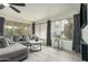 Cozy living room with gray tones, fan, and updated flooring with views of the backyard at 9918 W Willow Creek Cir, Sun City, AZ 85373