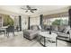 Cozy living room with gray tones, fan, and updated flooring with views of the backyard at 9918 W Willow Creek Cir, Sun City, AZ 85373