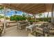 Covered patio with outdoor seating and a view of the landscaped backyard at 9918 W Willow Creek Cir, Sun City, AZ 85373