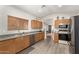 Functional kitchen featuring stainless steel appliances, wood cabinets, and a view of the living area at 9948 N 94Th Ave, Peoria, AZ 85345