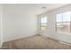 Well-lit bedroom with carpet, windows, and a view of the neighborhood at 11605 W Green Dr, Youngtown, AZ 85363