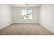 Bedroom with plush carpeting, white walls, base trim, and a large window for natural light at 11605 W Green Dr, Youngtown, AZ 85363