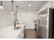Bright kitchen featuring stainless steel appliances, white cabinets, a large island with sink, and modern pendant lighting at 11605 W Green Dr, Youngtown, AZ 85363