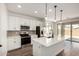 Modern kitchen with white cabinetry, stainless steel appliances, a central island with pendant lighting, and wood look flooring at 11605 W Green Dr, Youngtown, AZ 85363