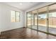 Bright living room featuring wood look flooring, sliding glass doors to the backyard, and a large window at 11605 W Green Dr, Youngtown, AZ 85363