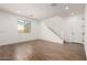 Living room featuring wood look flooring, white walls, a large window, and a staircase leading to the second floor at 11605 W Green Dr, Youngtown, AZ 85363