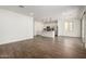 Open floor plan with wood look flooring, leading to a modern kitchen with stainless appliances and a large sliding glass door at 11605 W Green Dr, Youngtown, AZ 85363