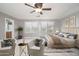 Bright, spacious bedroom with a ceiling fan, plush armchairs, and a luxurious king-sized bed with plenty of pillows at 13346 W Jesse Red Dr, Peoria, AZ 85383