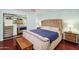 Well-lit primary bedroom with a tufted headboard, wooden floors, and mirrored closet at 15440 E Mustang Dr, Fountain Hills, AZ 85268