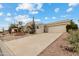 View of the front exterior of a desert-landscaped home with a circular fountain in the front yard at 15440 E Mustang Dr, Fountain Hills, AZ 85268