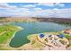 Scenic aerial view showcasing a vast lake, green park areas, and a playground under a partly cloudy sky at 15510 E Sycamore Dr, Fountain Hills, AZ 85268