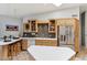 Modern kitchen with tile floors, stainless steel fridge, and breakfast bar seating at 15510 E Sycamore Dr, Fountain Hills, AZ 85268