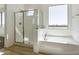 Bright bathroom featuring a bathtub, a walk-in shower and a large window at 15675 W Mercer Ln, Surprise, AZ 85379