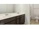 Bathroom with dual sinks and a view of the toilet and shower at 15675 W Mercer Ln, Surprise, AZ 85379