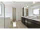 Bathroom featuring double sink vanity, modern lighting, and a glass-enclosed shower at 15675 W Mercer Ln, Surprise, AZ 85379