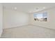 A well-lit carpeted bedroom features a large window that provides natural light at 15675 W Mercer Ln, Surprise, AZ 85379