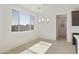 Dining area featuring a modern chandelier and a large window with backyard views at 15675 W Mercer Ln, Surprise, AZ 85379