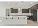 Kitchen featuring quartz countertops, modern stainless steel appliances, and dark wood cabinets at 15675 W Mercer Ln, Surprise, AZ 85379