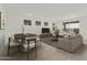 Stylishly decorated living room with dining area featuring hardwood floors and ample seating at 15675 W Mercer Ln, Surprise, AZ 85379