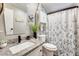 Bathroom featuring a granite look vanity, cabinet storage and a shower-tub combo with a floral shower curtain at 1669 N Suncrest Ave, Casa Grande, AZ 85122