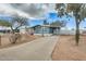 Charming blue home featuring a covered carport, well-maintained yard, and mature desert landscaping at 1669 N Suncrest Ave, Casa Grande, AZ 85122