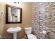 Stylish half bath features a pedestal sink, decorative mirror and mosaic tile accent wall at 1708 W Dusty Wren Dr, Phoenix, AZ 85085