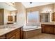 Elegant bathroom with a large soaking tub, granite countertops, and stylish light fixtures at 1708 W Dusty Wren Dr, Phoenix, AZ 85085