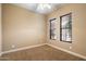 Cozy bedroom featuring tan carpet, light-colored walls, and two windows covered with blinds at 1708 W Dusty Wren Dr, Phoenix, AZ 85085