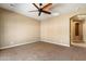 Spacious bedroom with tan carpet, neutral paint, ceiling fan, and an adjoining room at 1708 W Dusty Wren Dr, Phoenix, AZ 85085