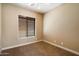 Neutral bedroom featuring tan carpet, light-colored walls, and a window covered with blinds at 1708 W Dusty Wren Dr, Phoenix, AZ 85085