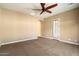 Large bedroom with beige carpet, neutral paint, ceiling fan, and view of an adjoining room at 1708 W Dusty Wren Dr, Phoenix, AZ 85085