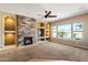 Inviting living room featuring large windows, a stone fireplace, and neutral walls at 1708 W Dusty Wren Dr, Phoenix, AZ 85085