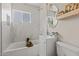 Elegant bathroom featuring marble tile walls, with an oval mirror, vanity, and bathtub, all bathed in natural light at 171 W Tulsa St, Chandler, AZ 85225