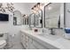 Bright bathroom featuring a double vanity with quartz countertops, modern fixtures, and decorative mirrors at 1725 W Marlette Ave, Phoenix, AZ 85015