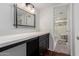 Bathroom vanity featuring dark cabinets and a glass door leading to the shower at 1725 W Marlette Ave, Phoenix, AZ 85015