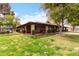 Community clubhouse with brick pillars, tile roof, manicured lawn, and mature trees, offers outdoor gathering space at 1725 W Marlette Ave, Phoenix, AZ 85015