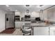 Kitchen featuring stainless appliances, granite counters, white cabinets, tile backsplash, and bar seating at 1725 W Marlette Ave, Phoenix, AZ 85015