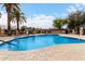 Inviting community pool with a safety rail, surrounded by palm trees, lounge chairs, and secure fencing at 1725 W Marlette Ave, Phoenix, AZ 85015