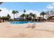 Community pool area surrounded by palm trees, lounge chairs, tables, and umbrellas for relaxation at 1725 W Marlette Ave, Phoenix, AZ 85015