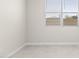 Neutral-walled bedroom with white trim, venetian blinds, and tile flooring at 17735 W Brown St, Waddell, AZ 85355