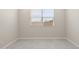 Bright bedroom with gray floors, a window with blinds, and neutral walls at 17735 W Brown St, Waddell, AZ 85355