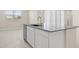 Kitchen with white cabinetry, gray countertops, dishwasher and stainless steel faucet at 17735 W Brown St, Waddell, AZ 85355