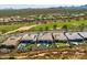 Expansive aerial view of homes with pools and green golf course in background at 18016 E Wolf Tree Ln, Rio Verde, AZ 85263